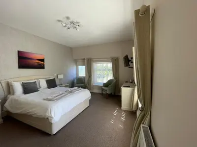 a bedroom with a white bed and a mirror at Bwch yn Uchaf B&B in Llanuwchllyn