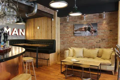 a living room with a couch and a brick wall at The Tilman in Barmouth