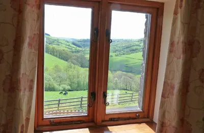 a room with a window with a view of a field at Beacons View Farm Cottages in Merthyr Cynog
