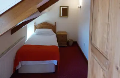 a small bedroom with a bed in a attic at Beacons View Farm Cottages in Merthyr Cynog