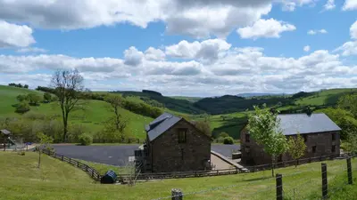 an old barn in the middle of a field at Beacons View Farm Cottages in Merthyr Cynog