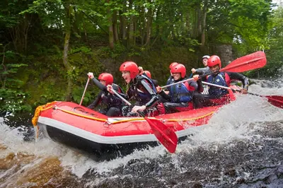 a group of people in a raft in a river at Becws Clyd in Trawsfynydd