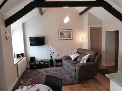 a living room with a couch and a table at Becws Clyd in Trawsfynydd