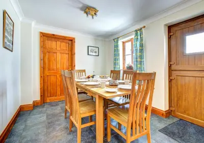 a dining room with a wooden table and chairs at Beudy Bach in Lampeter
