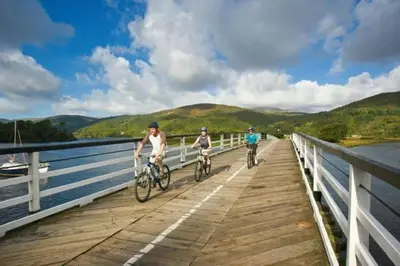 a couple of people riding bikes on a bridge at Beudy Taicroesion in Barmouth