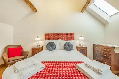a bedroom with a large bed with a red blanket at 2 Bed in Bala oc-82768 in Llandderfel