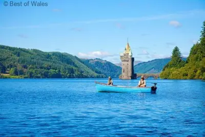 three people in a boat on a lake with a castle at 2 Bed in Welshpool oc-75703 in Meifod