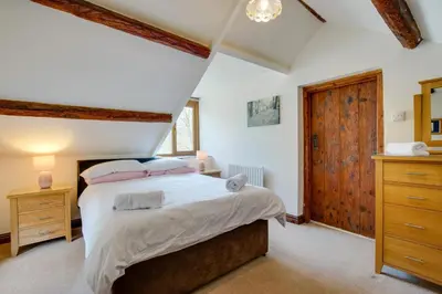 a bedroom with a large bed and a wooden door at 2 Bed in Aberdyfi oc-78258 in Pennal