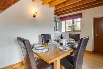 a dining room with a wooden table and chairs at 2 Bed in Aberdyfi oc-78258 in Pennal