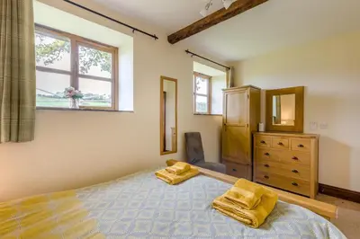 a bedroom with a bed and a dresser and a window at 2 Bed in Builth Wells oc-39471 in Builth Wells