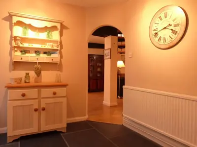 a hallway with a clock on the wall at Drws y Nant in Dolgellau