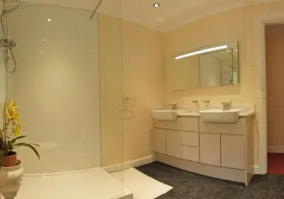 a bathroom with a shower and a sink and a tub at Gerddi'r Coed in Dolgellau