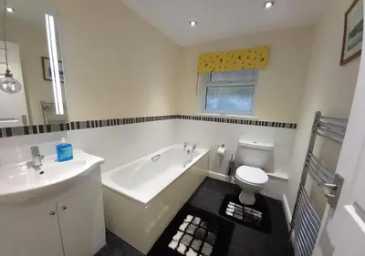 a bathroom with a tub and a toilet and a sink at Gerddi'r Coed in Dolgellau