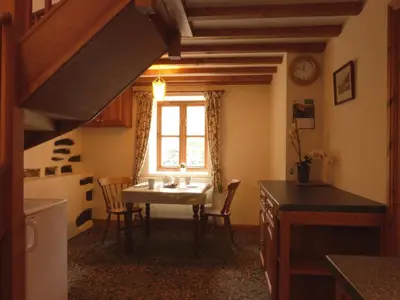 a kitchen with a table and chairs and a window at Granar Gynolwyn in Abergynolwyn