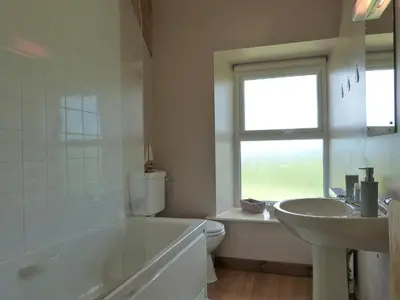 a bathroom with a tub and a sink and a toilet at Gwarcwm Uchaf in Tre-Taliesin