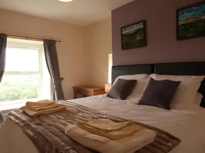 a bedroom with a bed with two towels on it at Gwarcwm Uchaf in Tre-Taliesin