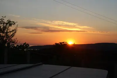 a sunset with the sun setting in the distance at Gwarcwm Uchaf in Tre-Taliesin