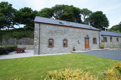 a small stone building with a grass yard at Llety'r Buarth in Talybont