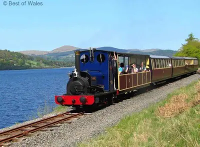 a train with passengers riding on the tracks near a body of water at 2 Bed in Bala oc-82212 in Bala