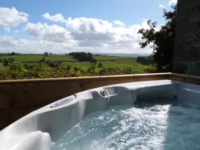 a jacuzzi tub with a view of the countryside at Tref y Nant in Castle Caereinion