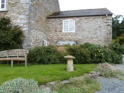 a bench and a birdbath in front of a building at Tref y Nant in Castle Caereinion
