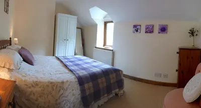 a bedroom with a large bed and a window at Troed yr Aran in Aber Cowarch