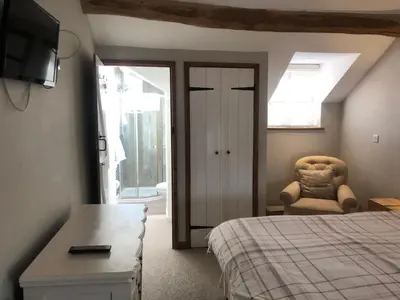 a bedroom with a bed and a chair and a window at Top House in Welshpool
