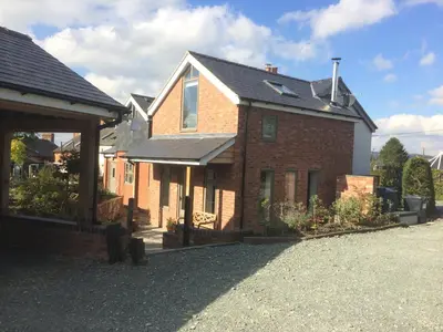 a brick house with a porch and a roof at Top House in Welshpool