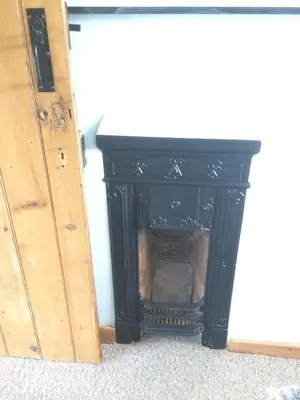 a black fireplace in the corner of a room at Top House in Welshpool