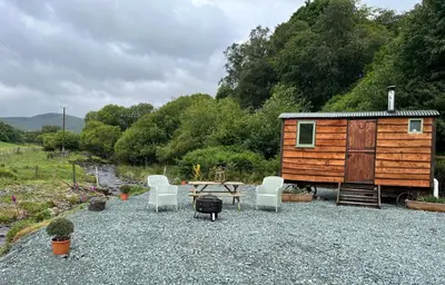 a cabin with a table and chairs and a table and chairs at Berwyn Shepherds Hut in Wrexham