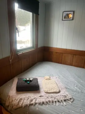 a room with a bed with a tray and a window at Berwyn Shepherds Hut in Wrexham