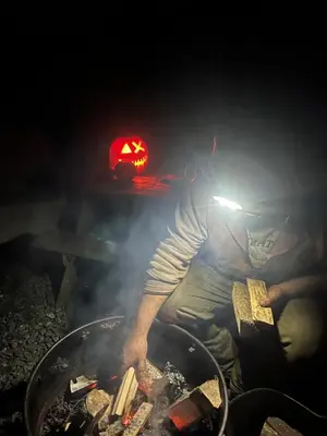 a man is cooking food on a grill at Berwyn Shepherds Hut in Wrexham