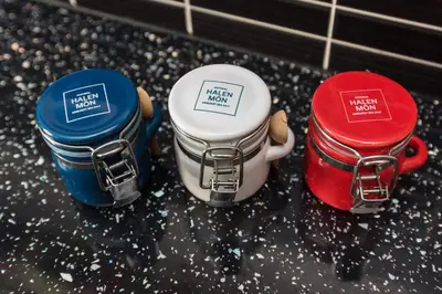 three different colored containers sitting on a kitchen counter at Sea view Ar Lan y Mor LUXURY APARTMENT in Aberystwyth