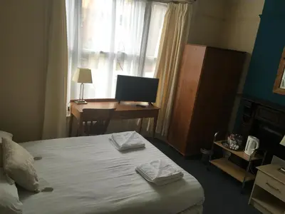 a bedroom with a bed and a desk with a computer at Four Seasons Budget in Aberystwyth