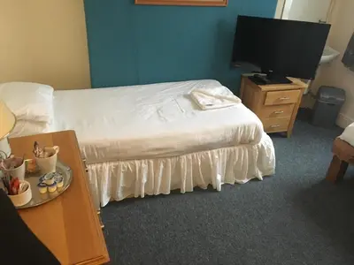 a hotel room with a bed and a flat screen tv at Four Seasons Budget in Aberystwyth