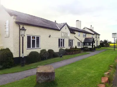 a white house with a street light in front of it at The Old Three Pigeons in Nesscliffe