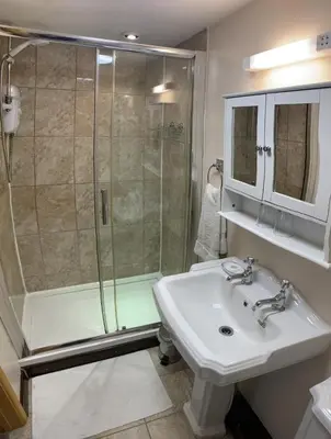 a bathroom with a sink and a shower at Ty Mawr at Bethania B&B Rooms and Crumble Cottage in Llanon