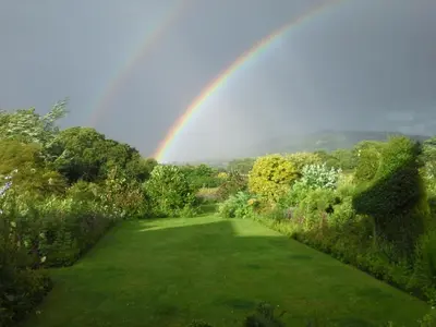 a rainbow in the sky over a garden at The Smithy in Hay-on-Wye