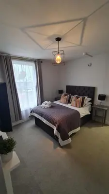 a bedroom with a bed and a large window at The Albert Hotel in Shrewsbury