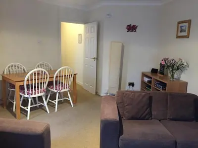 a living room with a couch and a table and chairs at No 6 Boleyn House in Brecon