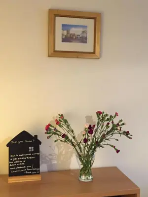 a vase of flowers sitting on a table with a sign at No 6 Boleyn House in Brecon