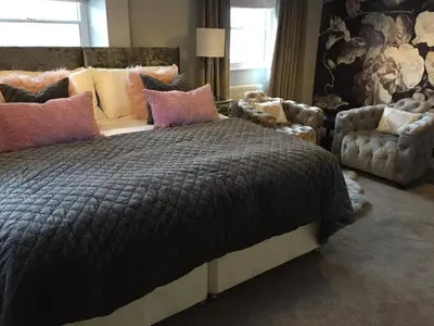 a bedroom with a bed and a couch and chairs at The Town House BnB in Brecon
