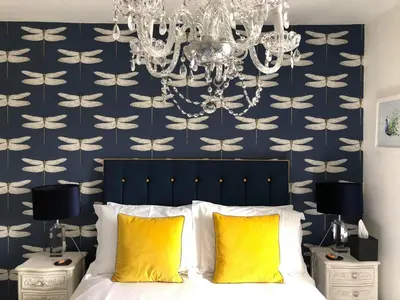 a bedroom with a chandelier and a bed with yellow pillows at The Town House BnB in Brecon