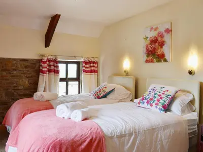 a bedroom with two beds with towels on them at Ty Coch Cottage in Dihewid