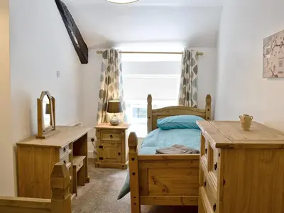 a bedroom with wooden furniture and a bed and a window at Pendref in Trawsfynydd