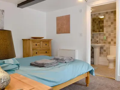 a bedroom with a bed and a bathroom with a sink at Pendref in Trawsfynydd