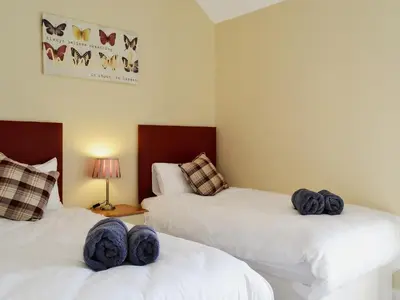 a bedroom with two beds with blue towels on them at Roath in Cilcennin