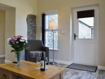 a living room with a table with a vase of flowers at Tawelfan in Cilcennin