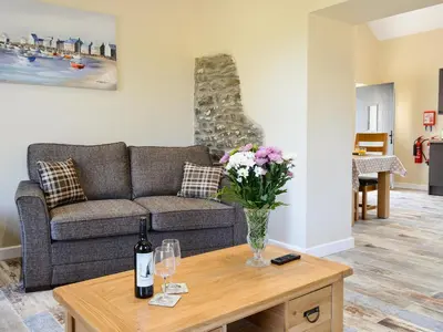 a living room with a couch and a table with flowers at Tawelfan in Cilcennin