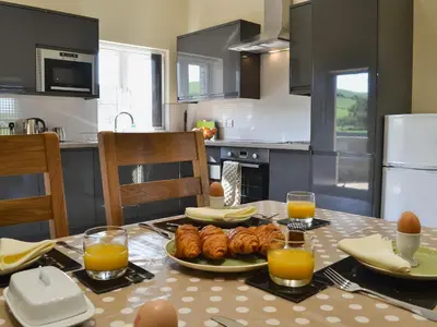 a kitchen with a table with a plate of food at Tawelfan in Cilcennin